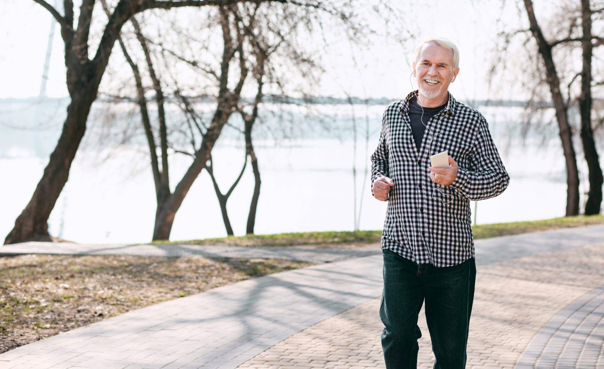 Enthusiastic senior man strolling in park