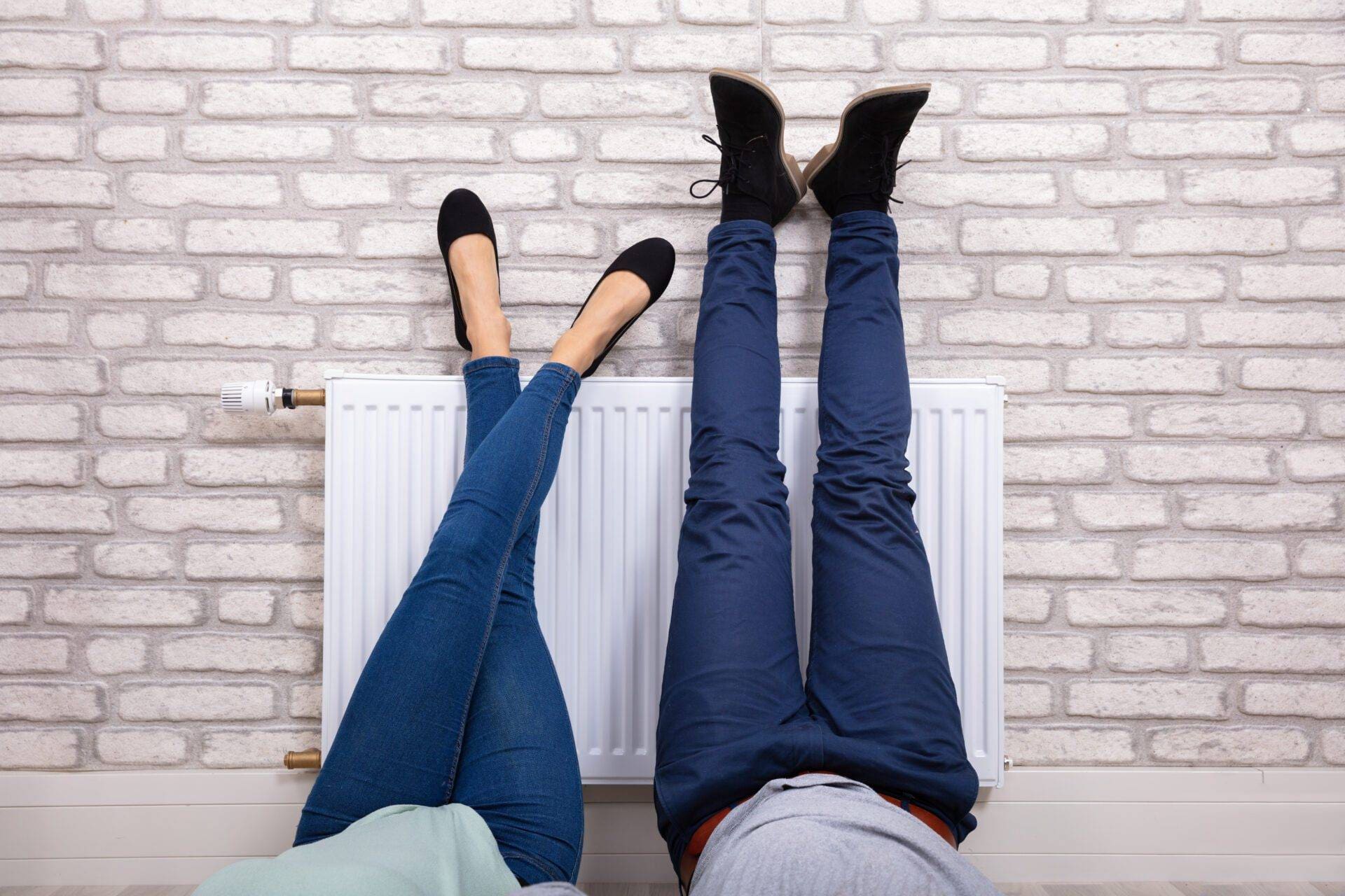 Couple Warming Up Their Feet On Radiator