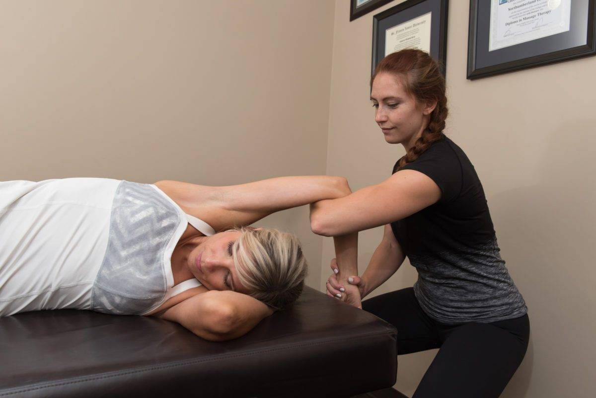 a woman is doing a hand stretch in a physiotherapy room